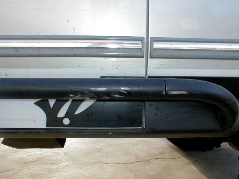 1996 Ford Bronco - Close-up of a vehicle's side panel and running board, showing a distinctive 'Y' emblem.