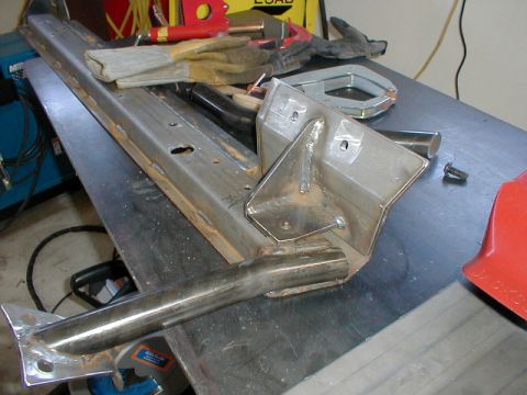 1996 Ford Bronco - Metal frame parts and welding supplies are laid out on a workbench.
