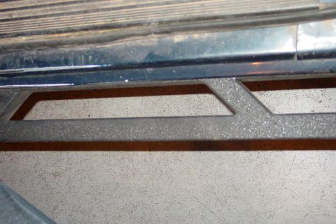 1993 Ford Bronco - A close-up view of a vehicle's running board, showing its textured surface and the ground beneath.