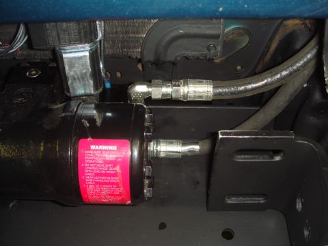 1996 Ford Bronco - Close-up of a winch motor and its hydraulic connections, with a prominent warning label.