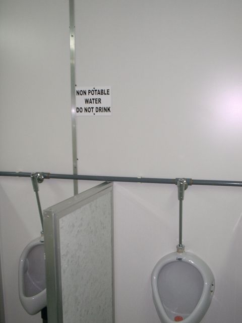 1996 Ford Bronco - A sign warns against drinking non-potable water in a restroom with urinals.
