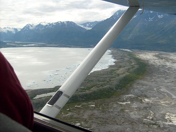 View from airplane window of Alaskan landscape with mountains and a lake