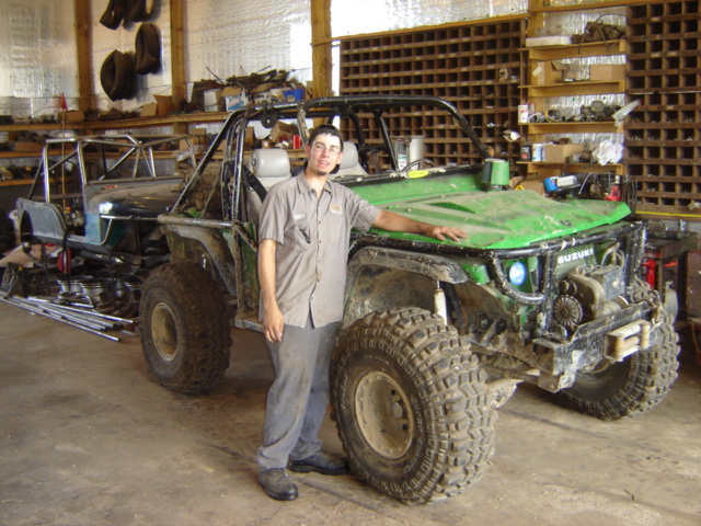 Guy next to a green Suzuki Samurai off-road build with another vehicle in the background