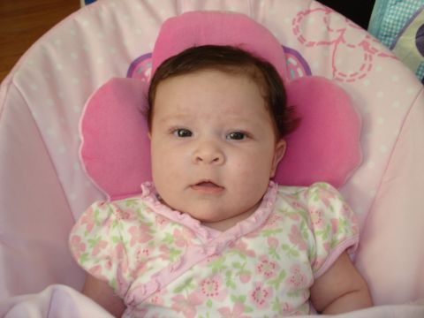 2000 Ford Crown Victoria - A baby girl is pictured in a pink floral onesie while resting in a pink baby bouncer.