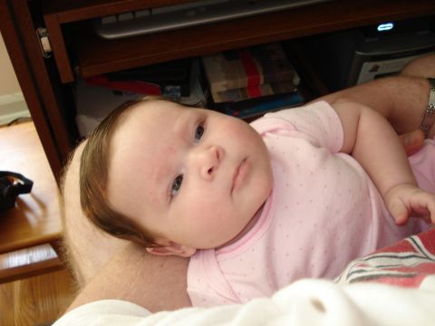 2000 Ford Crown Victoria - Baby in a pink onesie rests on someone's lap.