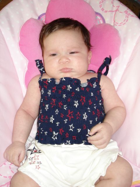 2000 Ford Crown Victoria - A baby is lying in a pink bouncer, wearing a patriotic-themed outfit.