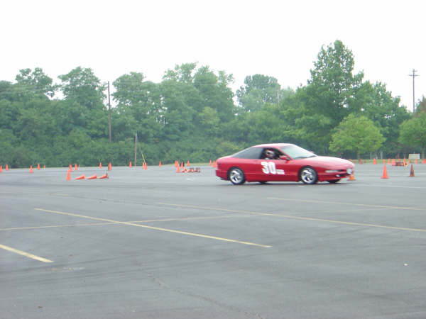 Red sports car with number 30 on the side driving on a track