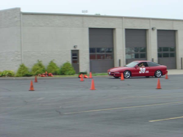 Red 1997 Ford Probe with racing number 30 on the door, driving on a track with orange cones