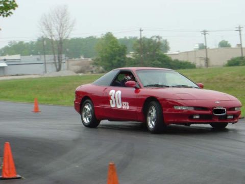 1997 Ford Probe - A red sports car navigates a track, marked with the number 30, during what appears to be a timed event.