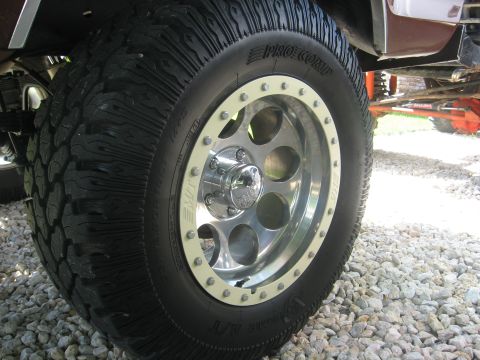 1979 Ford Bronco - This image shows a close-up view of a Pro Comp off-road tire mounted on a shiny chrome wheel.