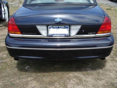 2000 Ford Crown Victoria - Rear view of a dark blue 2000 Ford Crown Victoria LX sedan, showing the "Crown Victoria LX" badging and New York license plates.