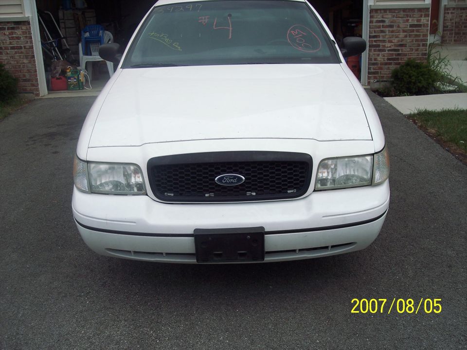 White Ford Crown Victoria parked in driveway. Front view