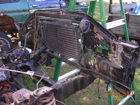 1978 Ford Bronco - The front end of a vehicle is disassembled, revealing the radiator and frame components.