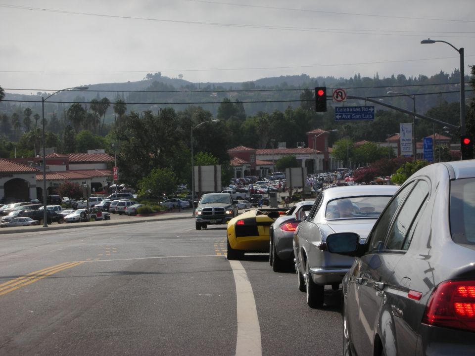 Traffic jam on a sunny day with a yellow sports car and silver cars visible