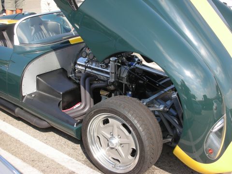 1998 Ford Crown Victoria - A green race car with yellow stripes is shown with its hood open, revealing the engine and front wheel assembly.