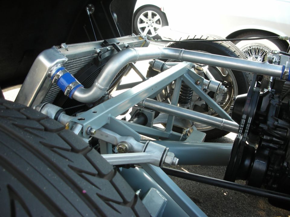 Custom suspension and radiator with blue hose clamps. Another car is visible in the background