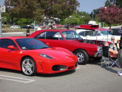 1998 Ford Crown Victoria - A red Ferrari and a red classic car are parked side-by-side at an outdoor gathering.