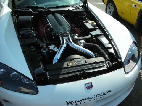 1998 Ford Crown Victoria - The engine bay of a white Dodge Viper is displayed, a twin-turbo setup and prominent "Venom 1000HP Twin Turbo" badging.