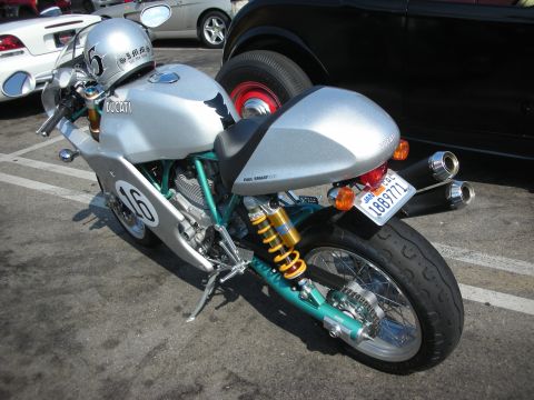 1998 Ford Crown Victoria - Silver Ducati motorcycle parked outdoors with other vehicles visible in the background.