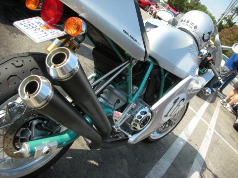 1998 Ford Crown Victoria - A close-up view of a silver Ducati motorcycle, dual exhaust pipes and a helmet resting on the seat.