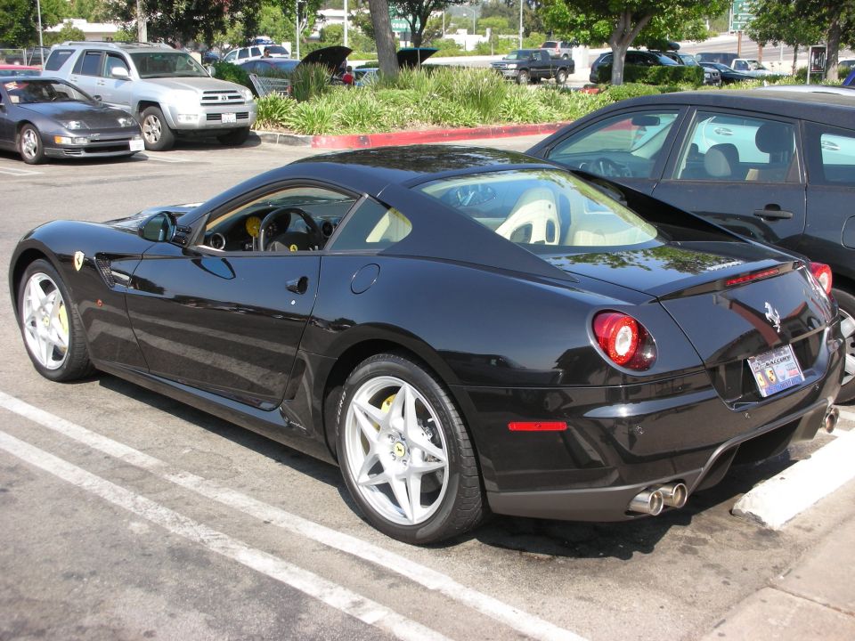 Black Ferrari coupe, rear 3/4 view, white interior