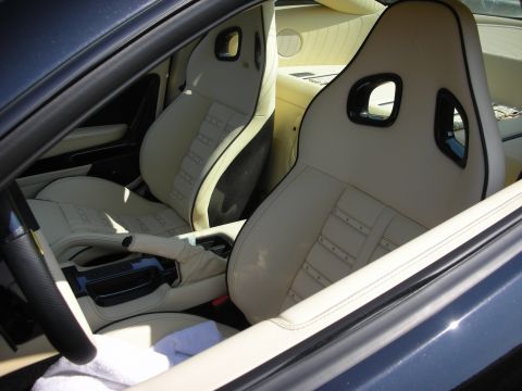 1998 Ford Crown Victoria - The interior of a car features cream racing seats with black accents and stitching.