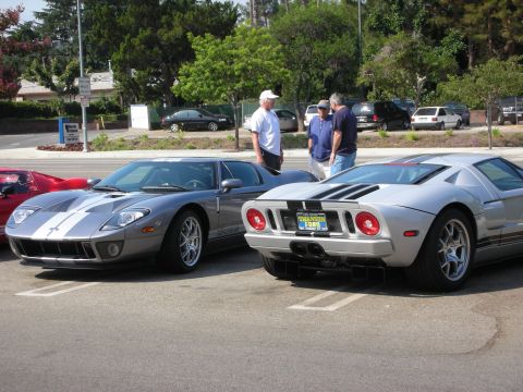 1998 Ford Crown Victoria - Two Ford GTs are parked side-by-side, with people standing between them.