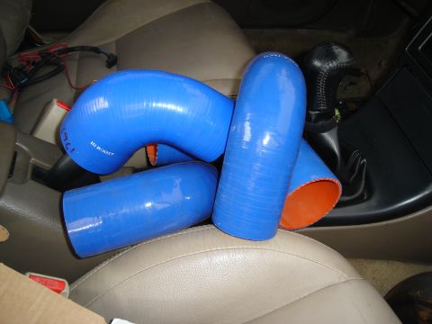 1995 Mazda MX-6 - Blue silicone hoses are shown inside a vehicle's interior, with text 'HI BOOST' visible on one.