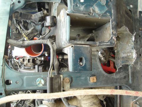 1995 Mazda MX-6 - This image shows the modified engine bay of a vehicle, with visible wiring, plumbing, and structural alterations.