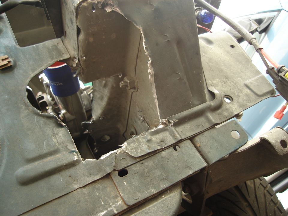 Damaged engine bay structure with a blue oil filter visible