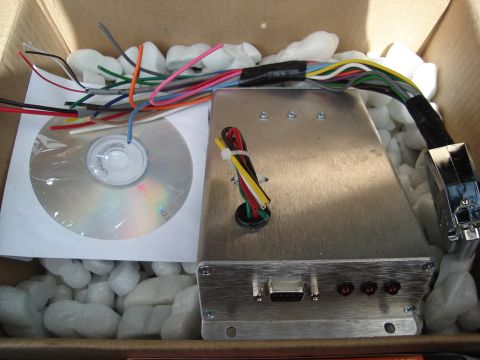 1995 Mazda MX-6 - An electronic control unit, CD, and wiring harness are packed in a box with foam peanuts.