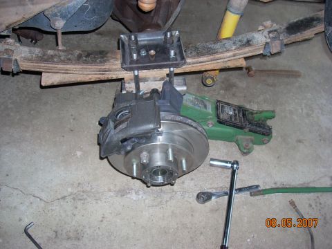 2000 Chevrolet Tahoe - A vehicle's rear brake assembly is shown with a jack supporting the axle and tools nearby.