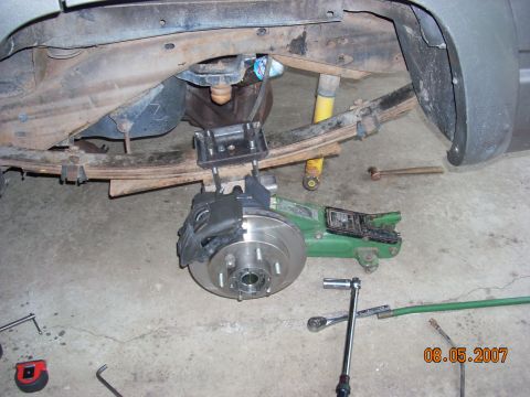 2000 Chevrolet Tahoe - Close-up view of a vehicle's rear suspension and braking system during maintenance.