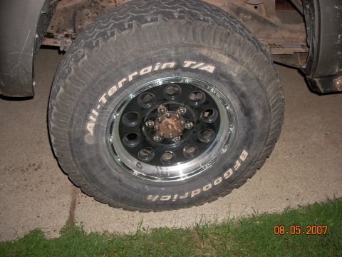 2000 Chevrolet Tahoe - Close-up of a BFGoodrich All-Terrain T/A tire mounted on a black multi-spoke wheel with a chrome lip.
