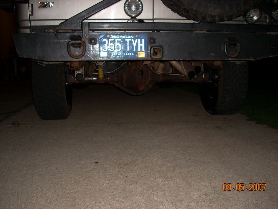 Rear view of a vehicle showing the axle, bumper, and Michigan license plate 355 TYH