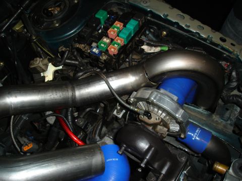 1995 Mazda MX-6 - Custom turbocharger and piping installed in the engine bay, with a visible fuse box.