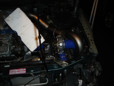 1995 Mazda MX-6 - Engine bay of a 1995 Mazda MX-6 showing a newly installed turbocharger and associated piping.