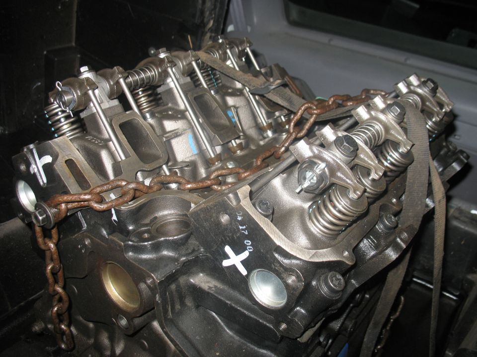 Engine block with rusty chain and straps, close-up view