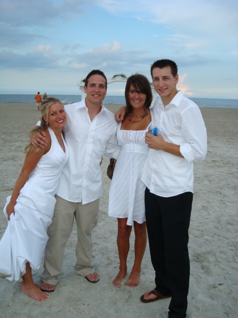 1989 Ford Bronco - A group of four people pose for a photo on a sandy beach during what appears to be a wedding or formal event.
