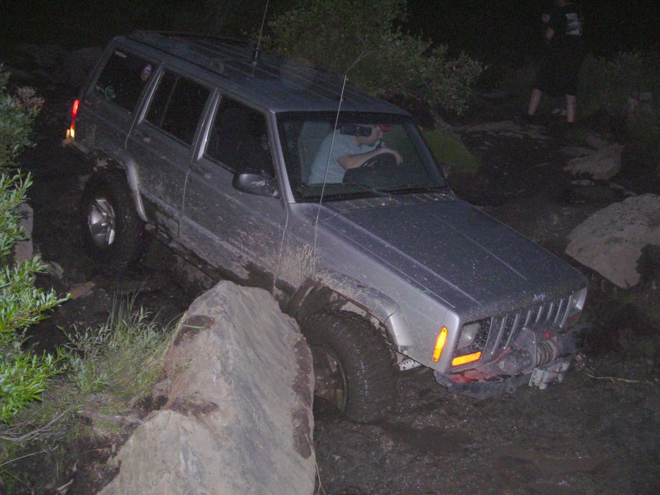 Silver Jeep Cherokee XJ navigating rocky terrain