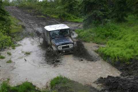 2003 Jeep TJ - This classic Toyota Land Cruiser navigates a challenging muddy trail.
