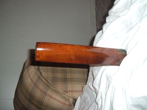 1919 Yugo Vega - A close-up view of a polished wooden stock, likely from a firearm, placed on furniture.