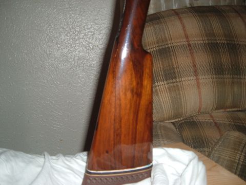 1919 Yugo Vega - Close-up of a polished wooden gun stock, intricate inlay work at the butt end.
