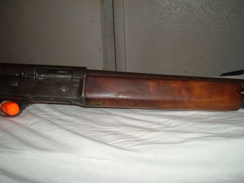 1919 Yugo Vega - A close-up view of a shotgun's receiver and wooden stock, resting on a white cloth.