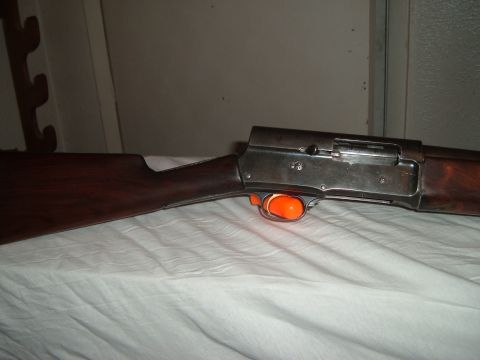 1919 Yugo Vega - A shotgun with a wooden stock and metal receiver is shown with an orange trigger guard.