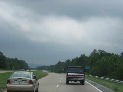 1995 Ford C-350 (Centurion Conversions) - Driving on a highway with a sedan and a pickup truck on a cloudy day.