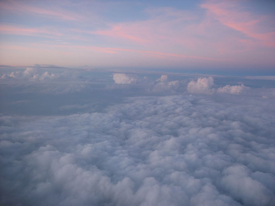 Clouds spread out below, with pink streaks in the sky above