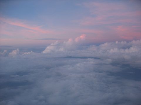 1995 Ford C-350 (Centurion Conversions) - A view from above the clouds during sunset, with hues of pink and blue in the sky.