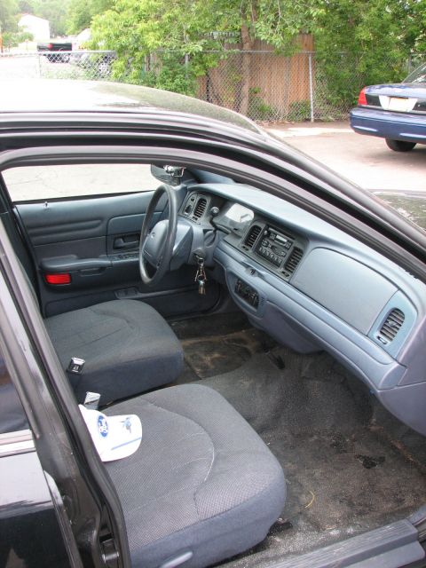 2000 Ford Crown Victoria - The interior of a Ford Crown Victoria is shown, with a second vehicle parked behind it.