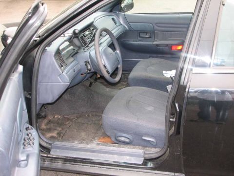 2000 Ford Crown Victoria - The interior of a black 2000 Ford Crown Victoria is shown with a focus on the driver's side.